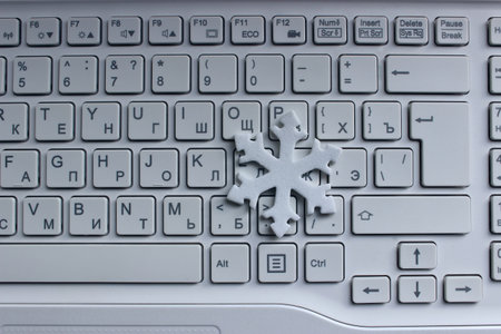 Snowflake Model on Bilingual Computer Keyboard. International Holidays Concept Image. Winter...