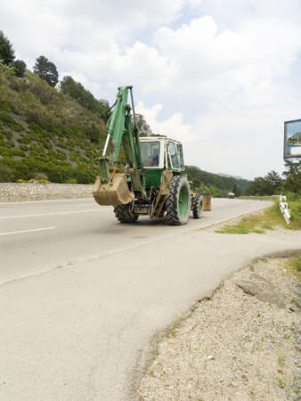 Tractor on highway. Clear sunny dayの写真素材