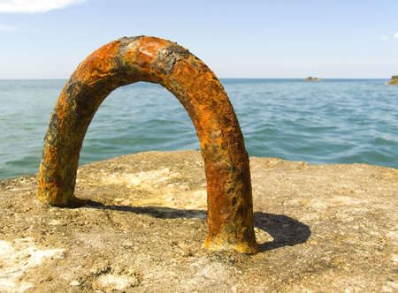 Rusty metal loop on a sea beachの写真素材