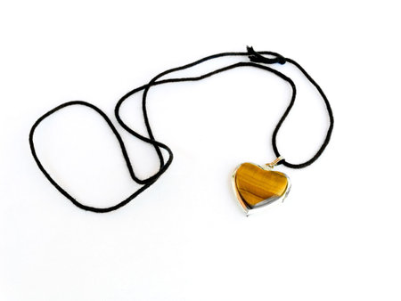 Amulet as heart on a black cordの写真素材