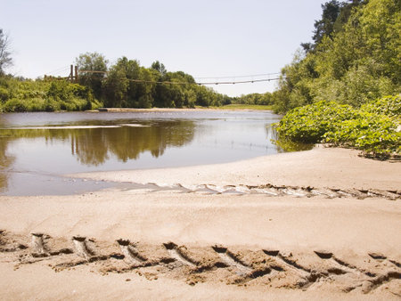 Ford on northern river. In the distance the pendant wooden bridge.の写真素材