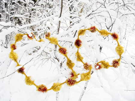Christmas garland on trees in a winter snow-covered wood