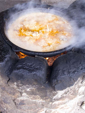 Soup in a saucepan prepares on fireの写真素材