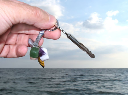 Charm with keys from a house on a background of the sea