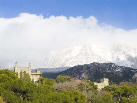Winter morning landscape with a palace in Crimea. On a background of mountain in a fog covered with snowの写真素材