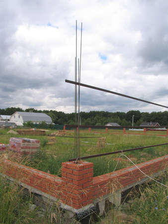 The construction of a new brick fence in red bricksの写真素材