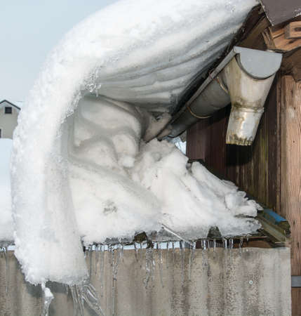 Snow falling down the roofの写真素材