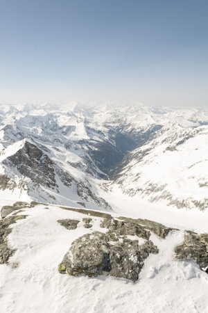 Rock covered with snow with mountain in the back, view from Ankogel, Austria
