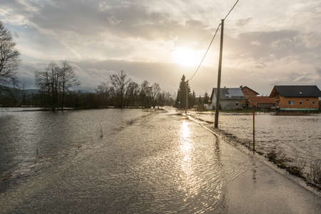 Road flooded after spring thaw with sun settingの写真素材