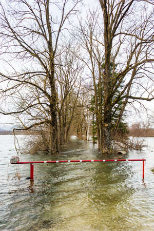 Barrier surrounded with water blocking a flooded roadの写真素材