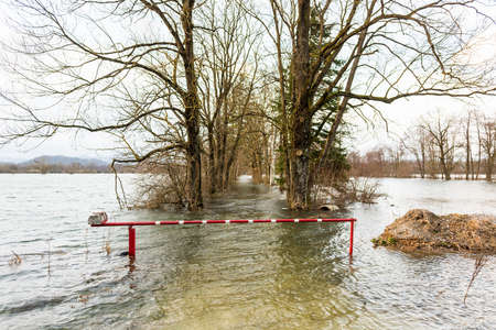 Barrier surrounded with water blocking a flooded roadの写真素材
