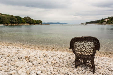Chair on a beach covered with pebbles, Santa Marina, Istra, Croatiaの写真素材