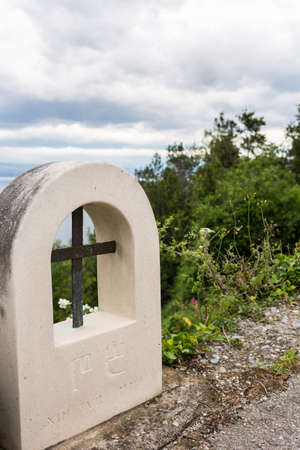 Stone road sign with an iron cross insideの写真素材