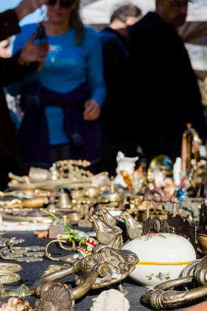 Object being sold on a flea market with visitors in the background.の写真素材