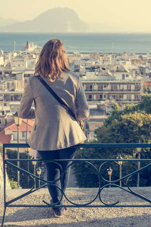 Business woman sitting on a bench above the city, Patras, Greeceの写真素材
