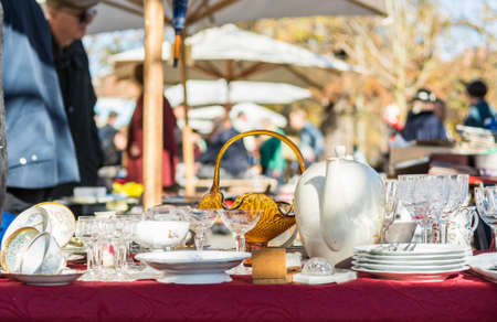 Object being sold on a flea market with visitors in the background.の写真素材