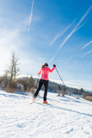 Woman cross country skiing. Shot in her back.の写真素材