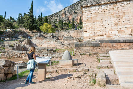 Visitor reading a description table at ancient Temple of Apollo, Delphi.の写真素材