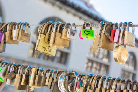 Pair of love locks on a bridge. River in the background.の写真素材