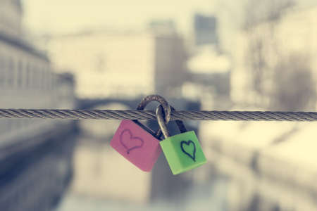 Pair of love locks on a bridge. River in the background.の写真素材