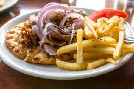 Plate of Greek lamb gyros with fries and onions. Greek speciality.の写真素材