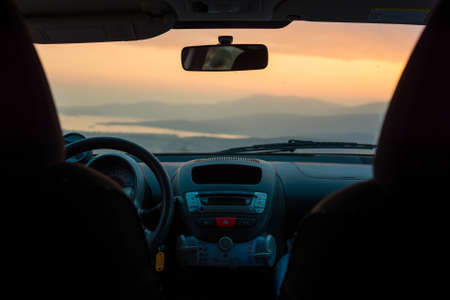 Dashboard view of a landscape at sunset. View from inside of a vehicle.の写真素材