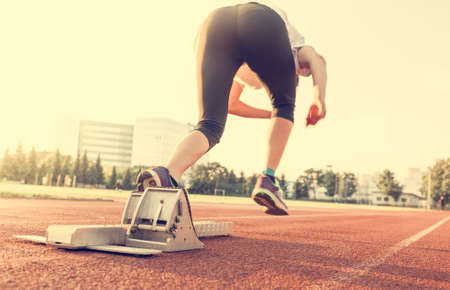 Side view of sprinter starting from a starting block.の写真素材