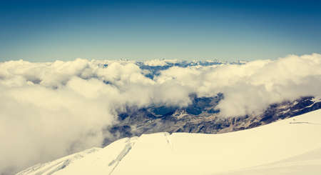 Mountain view. Spectacular panorama with clouds bellow glacier.の写真素材
