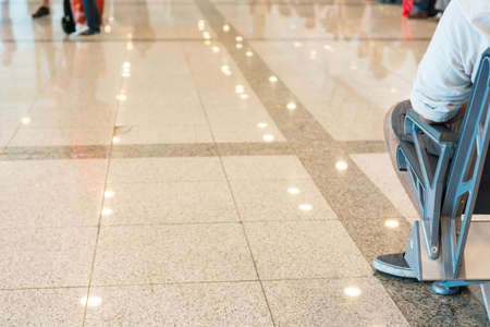 Airport waiting room.  Close up of person sitting on a bench.の写真素材