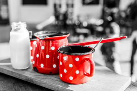Retro coffee set. Red metal cups with white dots and milk bottle.の写真素材