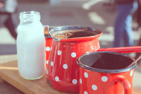 Retro coffee set. Red metal cups with white dots and milk bottle.の写真素材