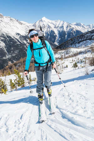 Young woman ascending a slope on skis. At Maltatal in Austria.の写真素材