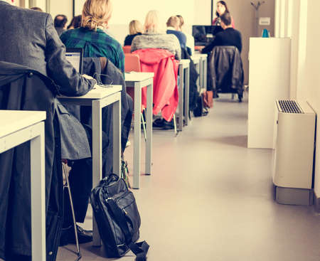 Closeup of classroom tables. Audience sitting down.の写真素材