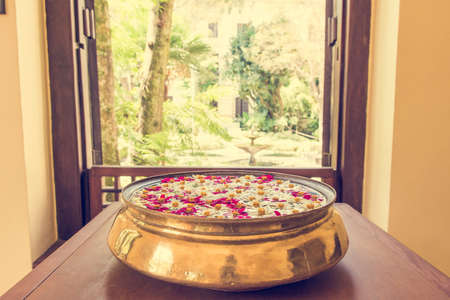 Flowers floating in water. Room with inviting decoration and garden view.の写真素材