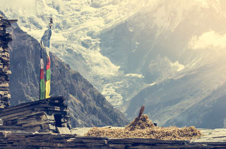 Mountain view, Annapurnas in Nepal. Wooden poles with buddhist flags.の写真素材