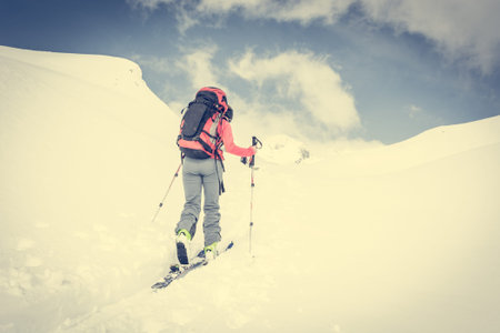 Attractive young skieer following a trail. Winter back country activity.