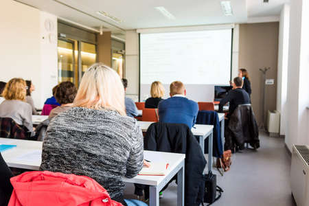 Business woman delivering a speach. Audience at a conference.の写真素材