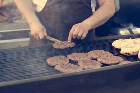 Burgers grilled on charcoal BBQ grill. Street food photography.の写真素材