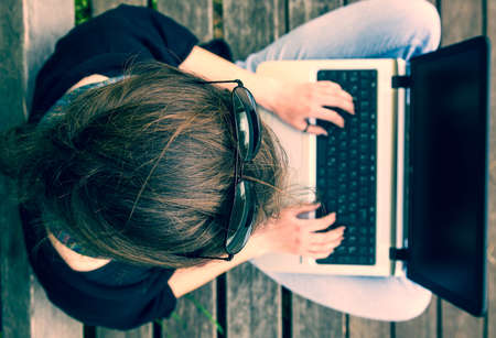 Young woman working on a laptop. View from above. Millenial generation.の写真素材
