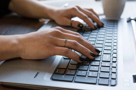Side view of woman's hands writing on laptop. Office concept.の写真素材