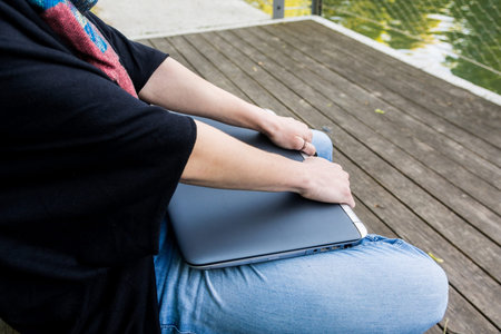 Closeup of hands resting on closed laptop. Enough work.