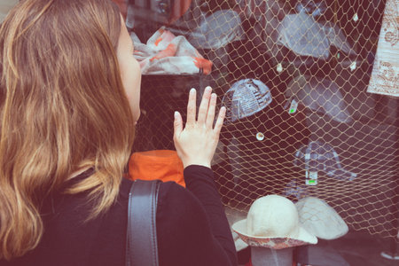 Attractive brunette window shopping. Rear view of a shopper.