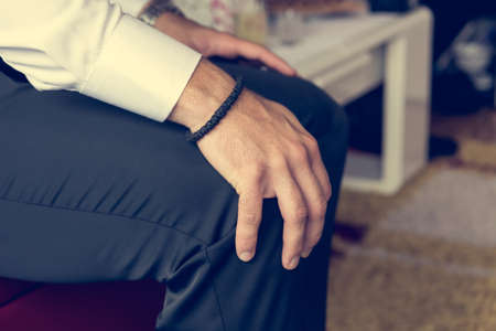 Closeup of hands holding knees. Groom waiting to leave for ceremony.の写真素材