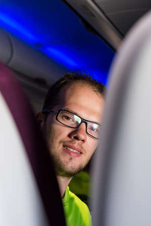 Young male looking back over passenger seats.の写真素材