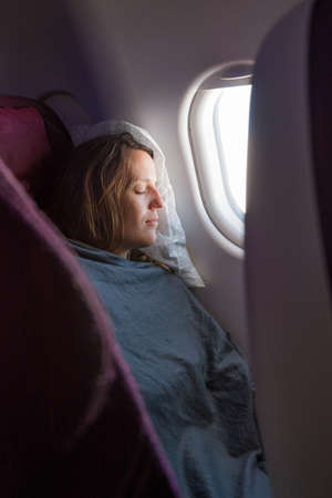 Female passenger sleeping covered with blanket.の写真素材