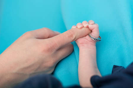 Newborn holding wedding ring.の写真素材
