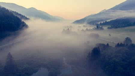 Aerial view mist hovering across a valley.の写真素材