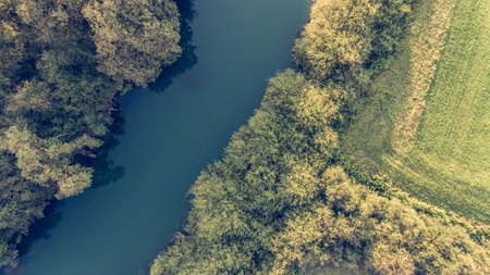 River bend surrounded by fields from birds eye view.の写真素材