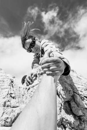 Female climber giving a helping hand.の写真素材