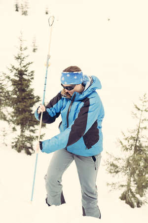 Female rescuer searching for avalanche victim.の写真素材